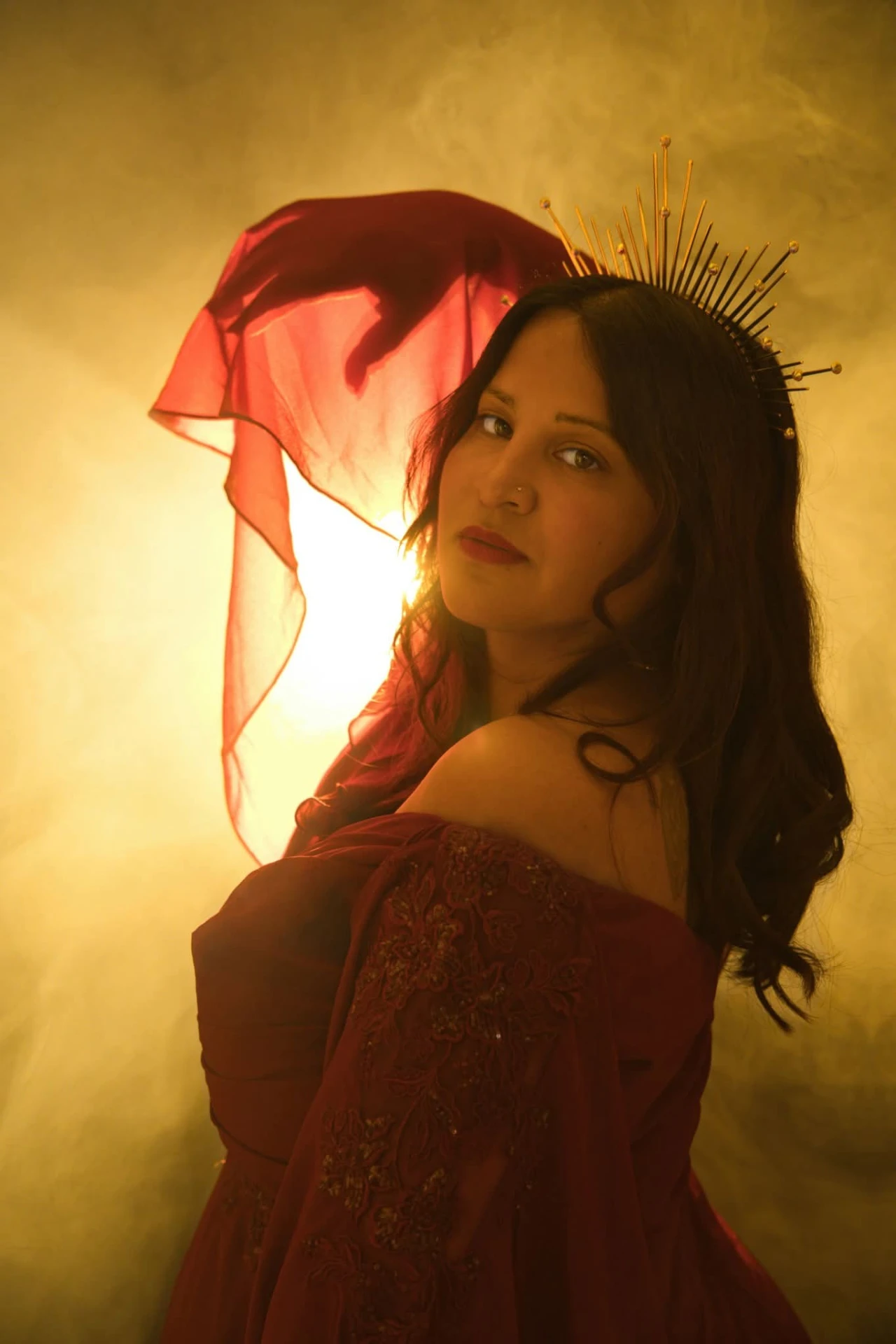 Katie Serenity couronnée, voilée de rouge, dans une lumière dorée